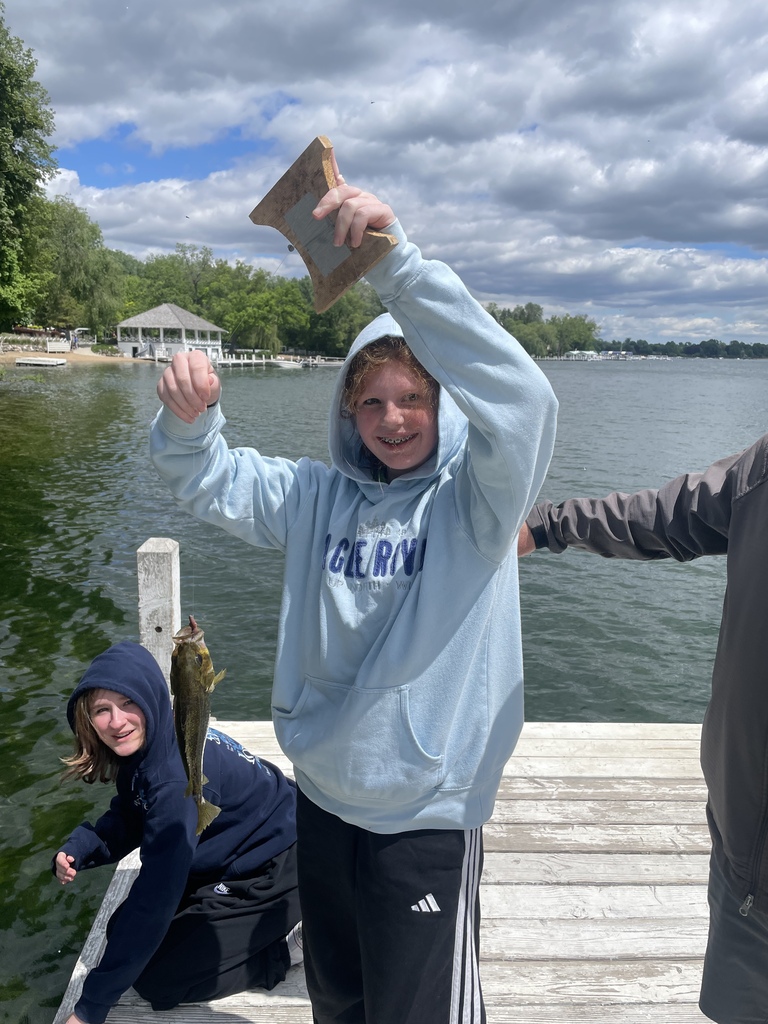 Student shows off fish they caught.