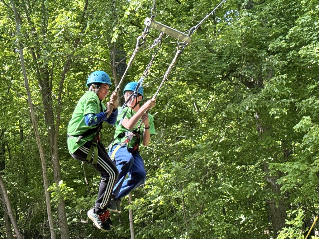 Two students swinging from ropes at Outdoor Ed.