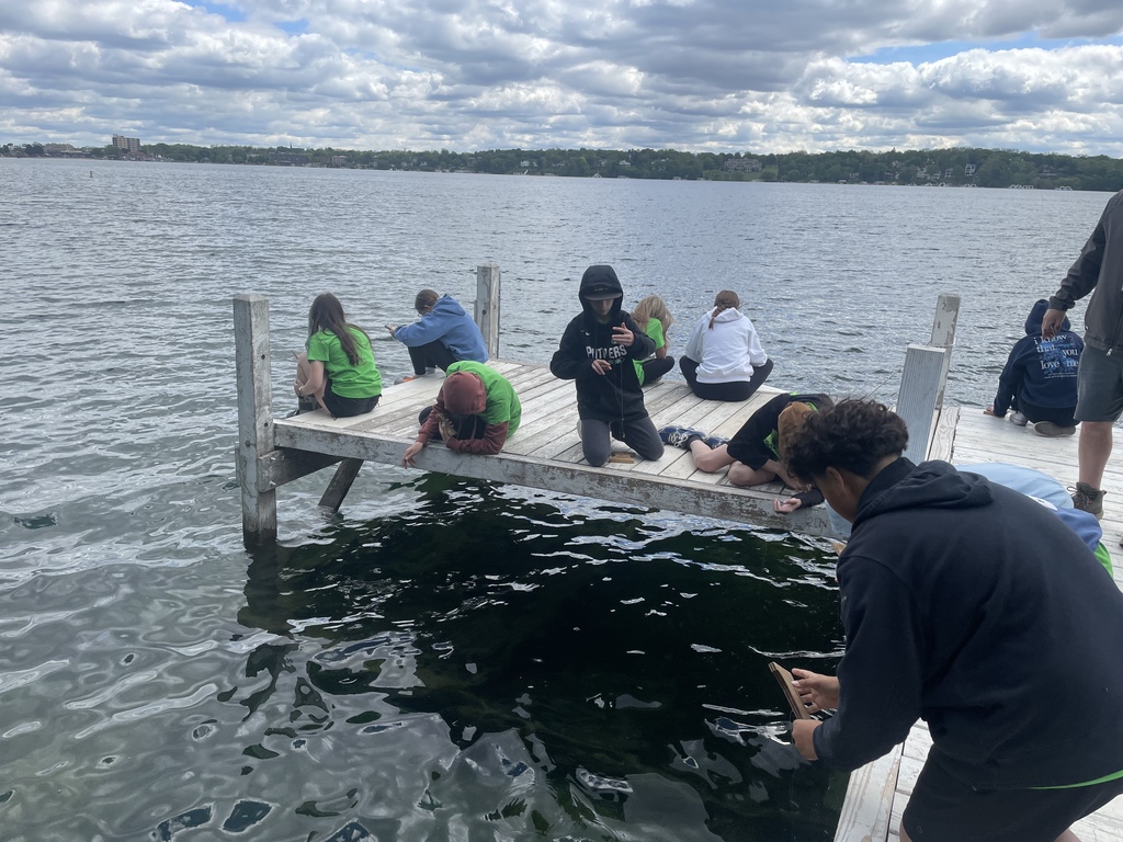 Students on a pier trying their hands at fishing.