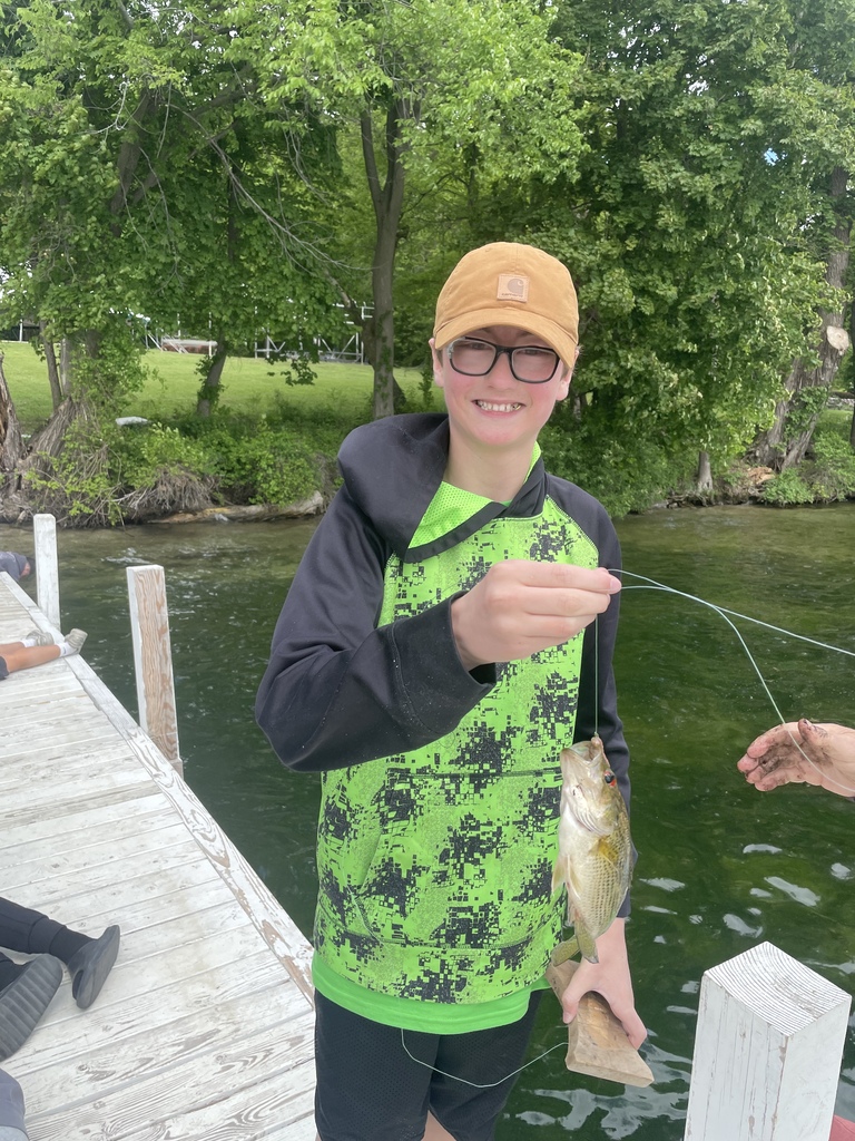 Student shows off fish they caught.