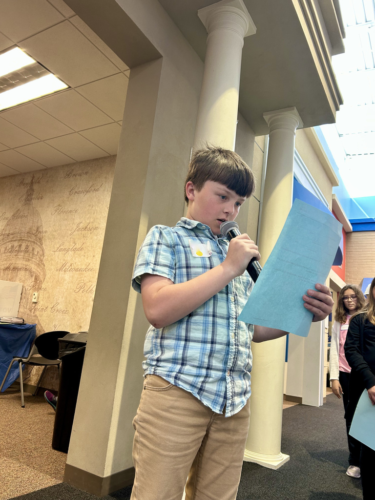 Student making a speech in front of a crowd at Biztown field trip