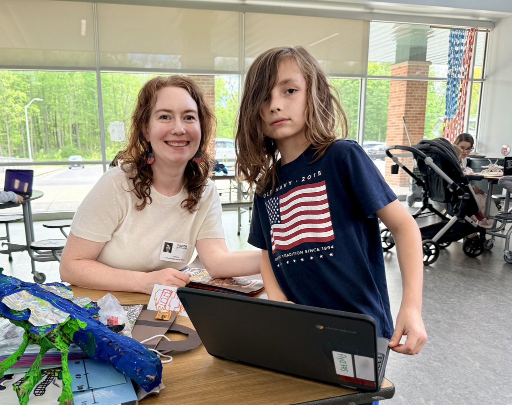 Student showing off the presentation of their school work to parent