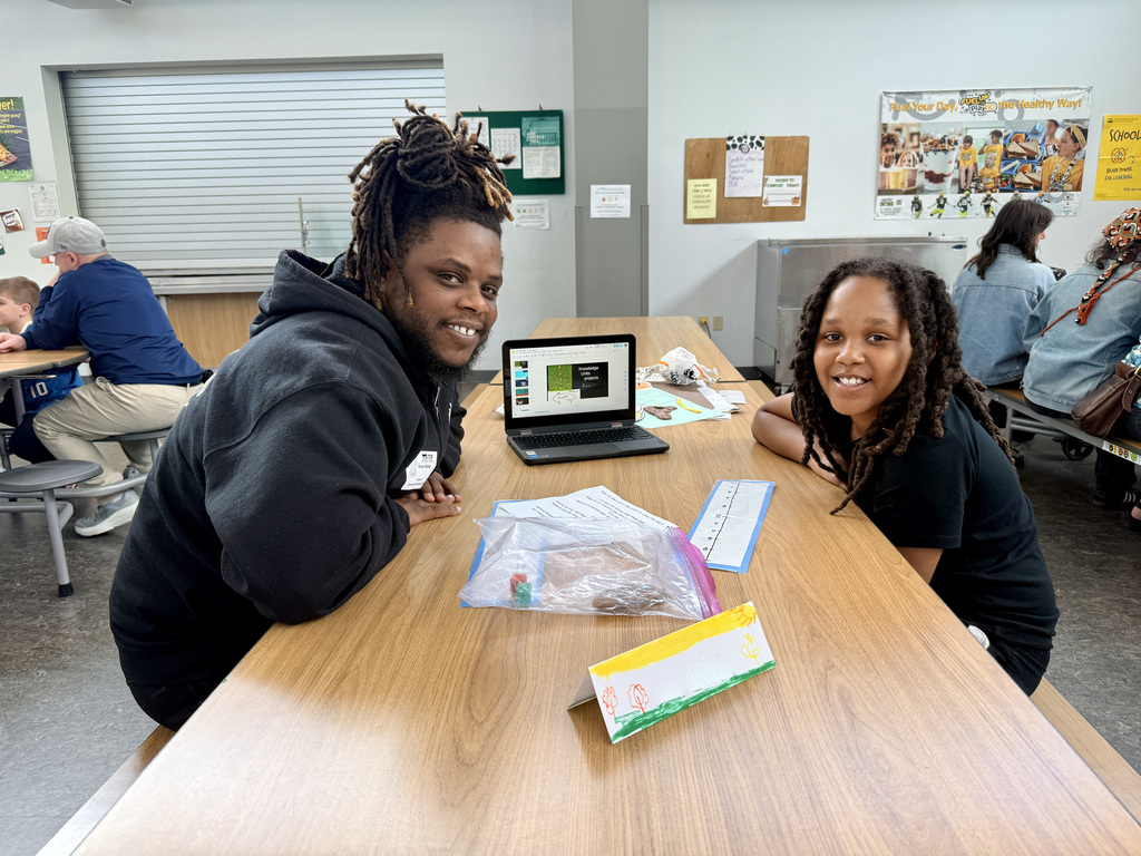 Student showing off the presentation of their school work to parent