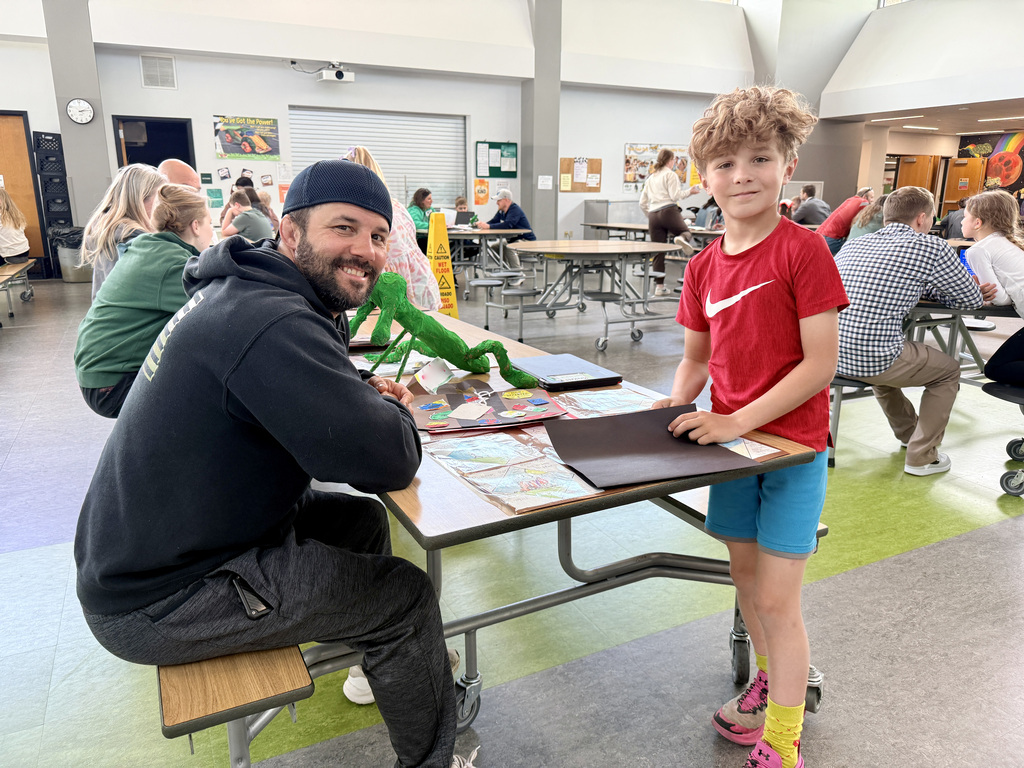 Student showing off the presentation of their school work to parent