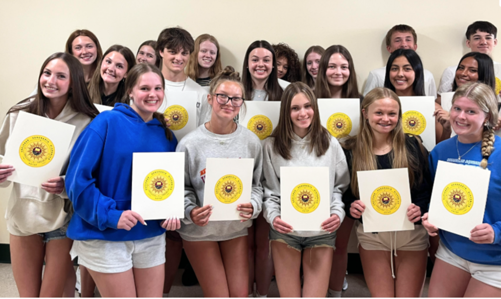 Smiling students pose and show off their National Spanish Honor Society certificates.