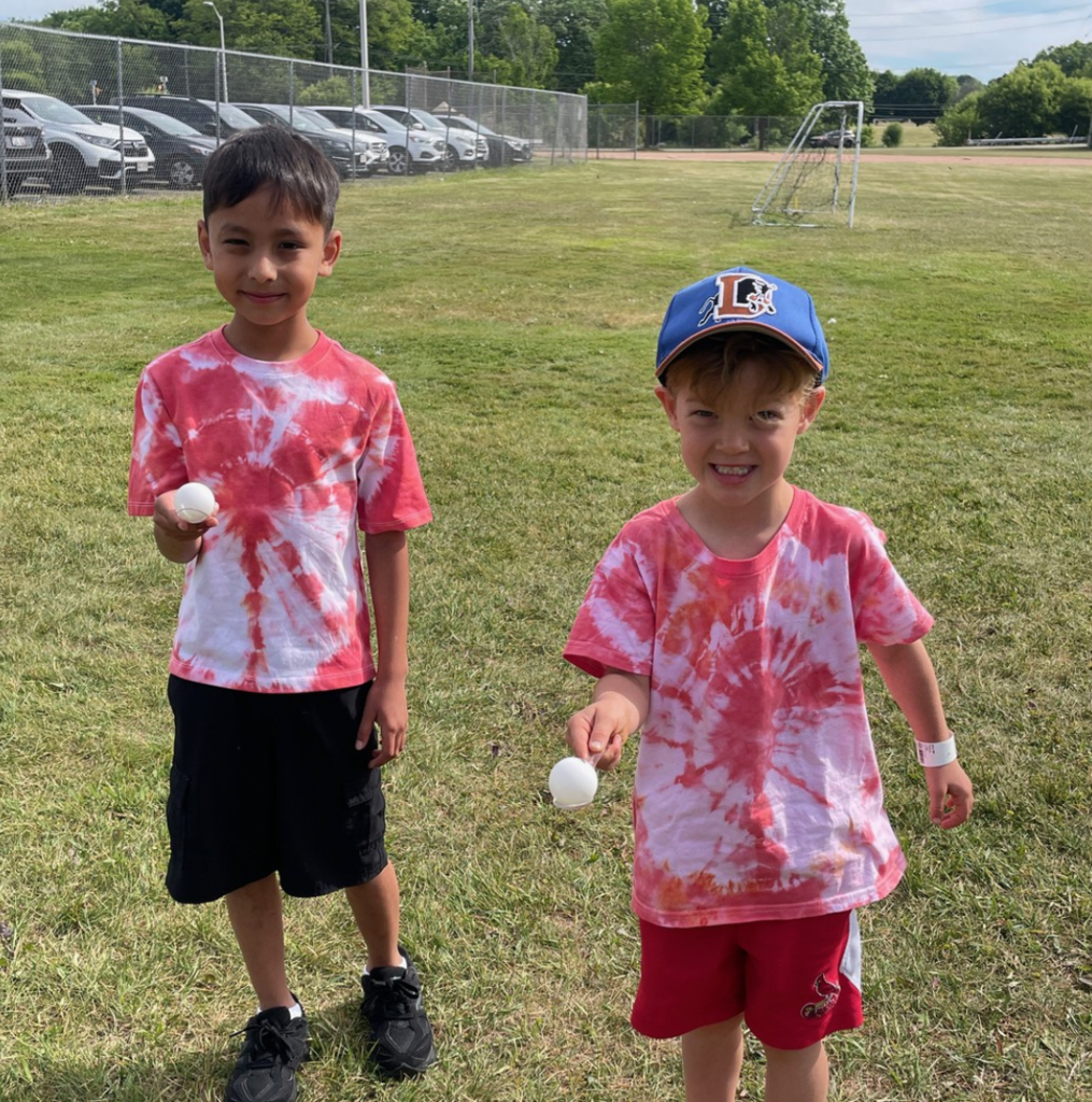 Two students walking with balls on a spoon during a field event during Olympic Day.