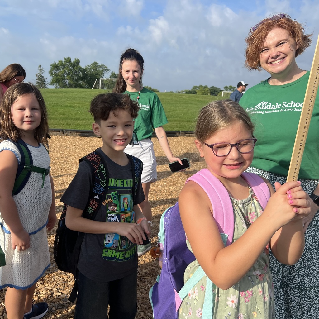 Students standing in a group and smiling with two staff members standing behind.