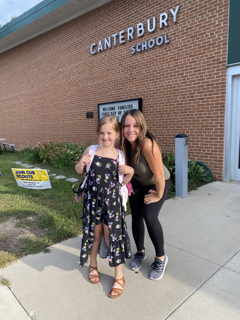 Mom and daughter posing in front of school sign