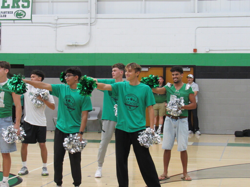 Guy poms standing and holding pompons before the dance.