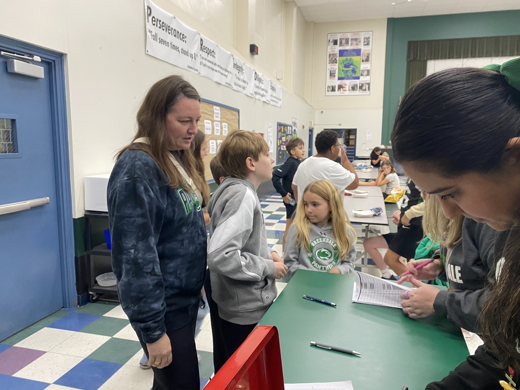 A family signing in to the event with other students standing around them