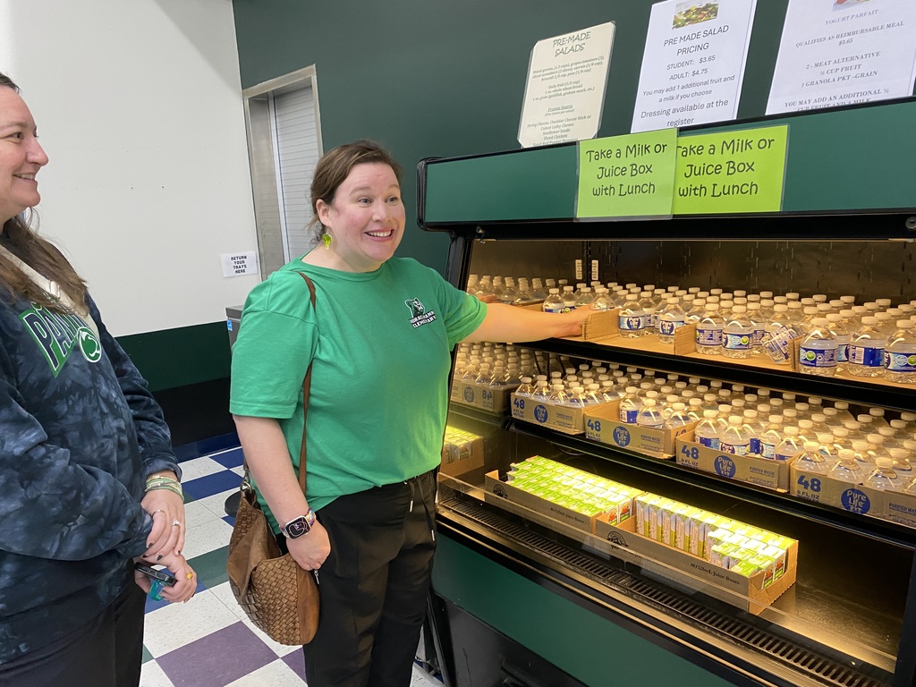 A lady selecting a water bottle from the cooler.