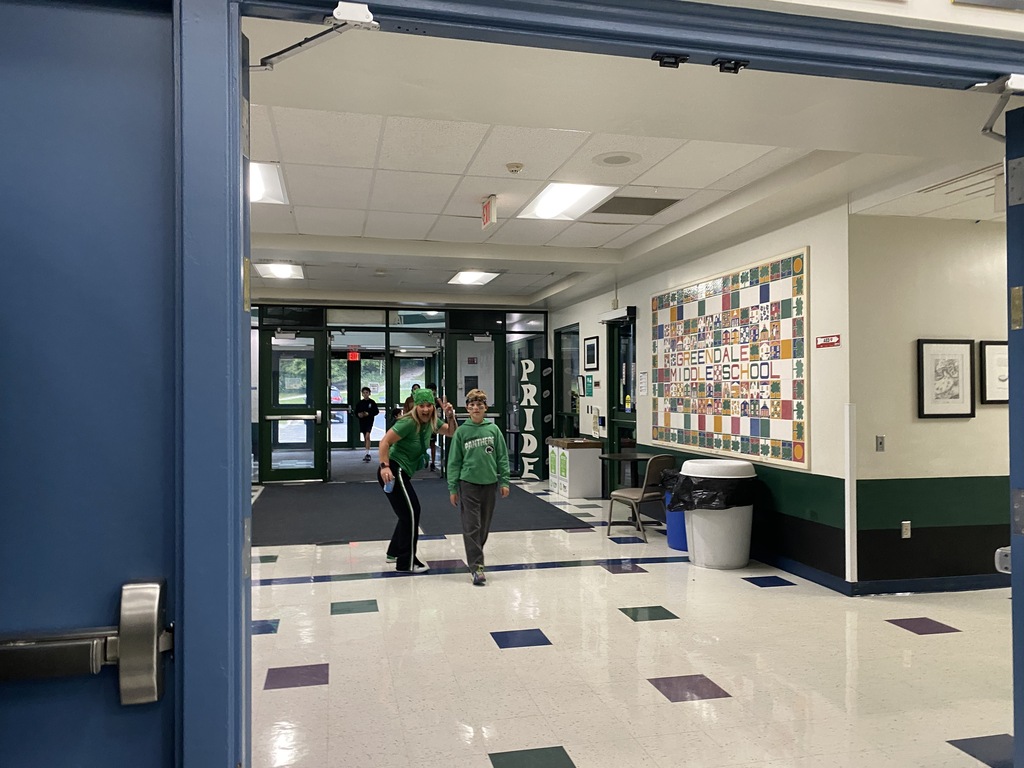 A teacher smiling as she walks with a youth toward the MPR