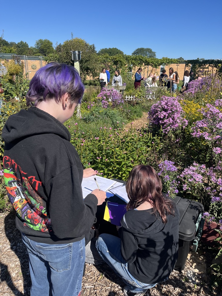 Students looking at plants and reading from a worksheet