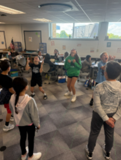 A class of fifth graders moving around the classroom in a sensory exercise to build descriptive writing skills.