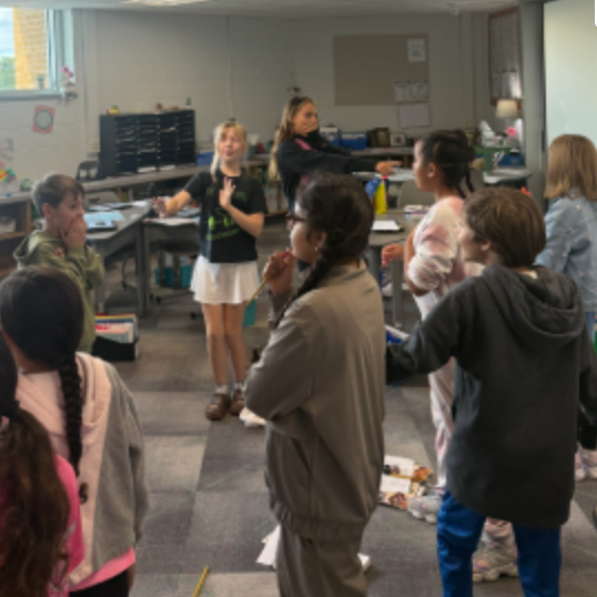 A class of fifth graders moving around the classroom in a sensory exercise to build descriptive writing skills.