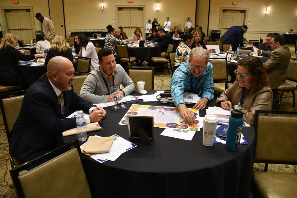Left to right around the table: Sullivan County Director of Schools Chuck Carter, head of Greeneville Middle School career education Michael Bowen, Kingsport City Schools career technical education head Bo Shadden and Alissa Lang, who runs East Tennessee State University’s Center of Excellence in STEM. They were playing a Get and Keep Your Job board game Junior Achievement presents in some area fifth grades during the Education to Employment Summit Wednesday in Kingsport.