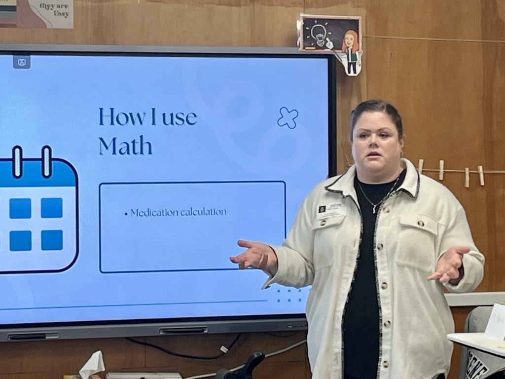 Guest speaker presenting how math is used in healthcare during a classroom talk.