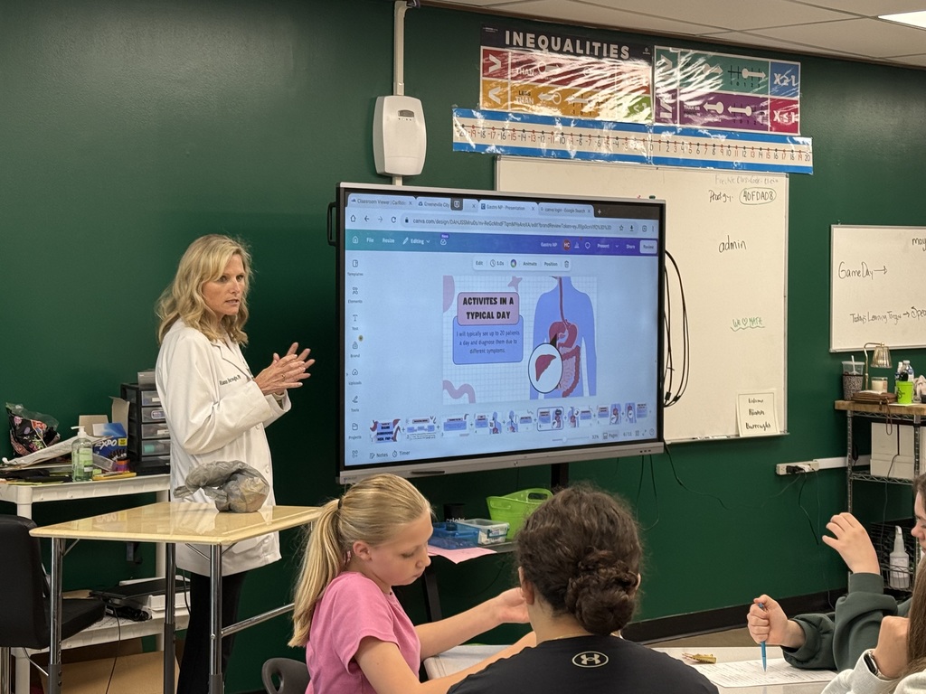 Healthcare professional presenting daily work activities using a classroom screen.