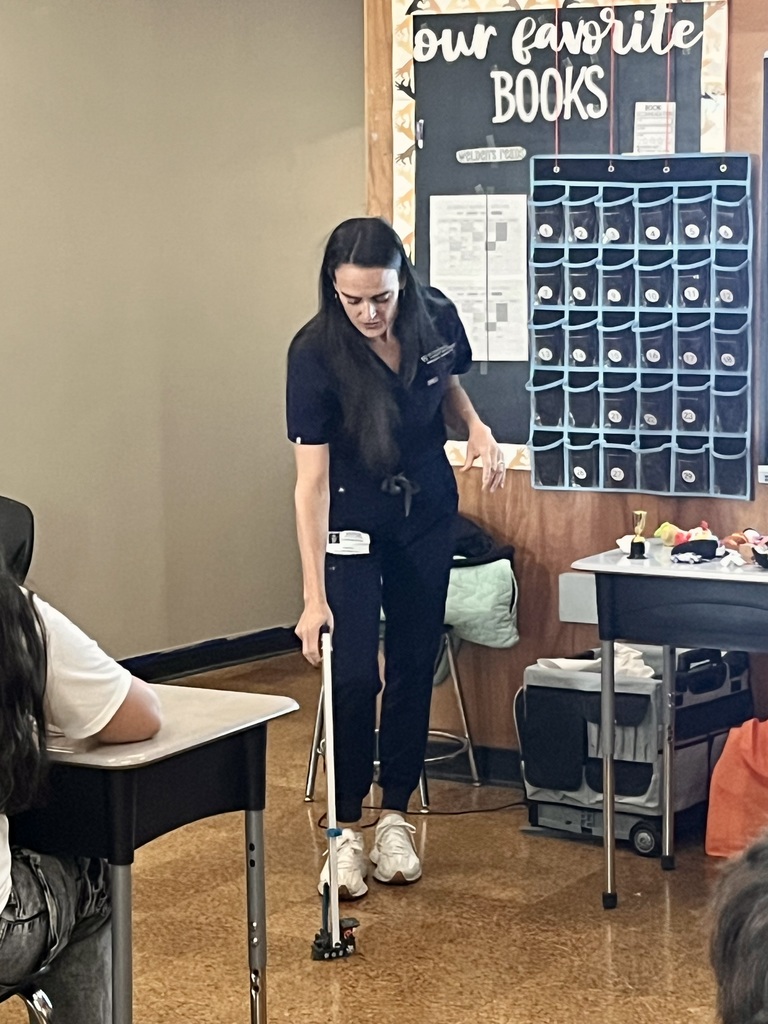 Guest speaker demonstrating a tool or equipment for students during career day.