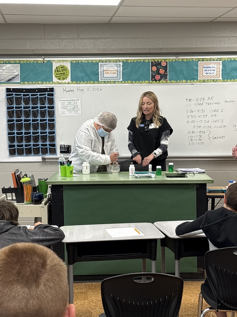 Students watch a hands-on demonstration mixing materials during a classroom career activity.