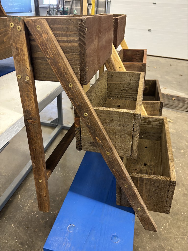 Side view of a three-tiered planter box in dark wood