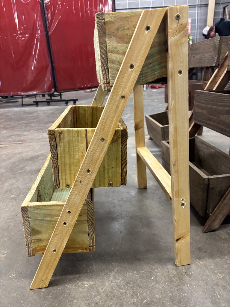 Side view of a three-tiered planter box in light wood