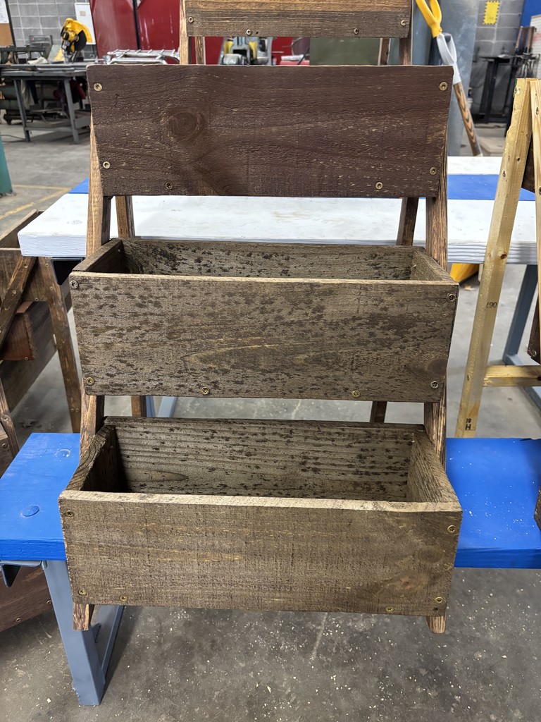 Front view of a three-tiered planter box in dark wood