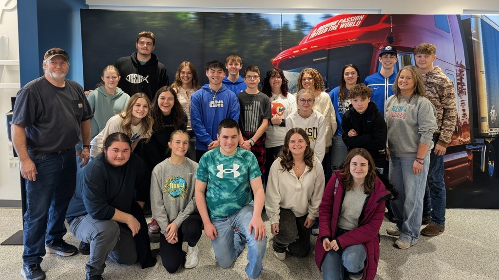 photo of Greenfield High School FBLA members and sponsors posing in front of a background featuring trees and a red semi truck