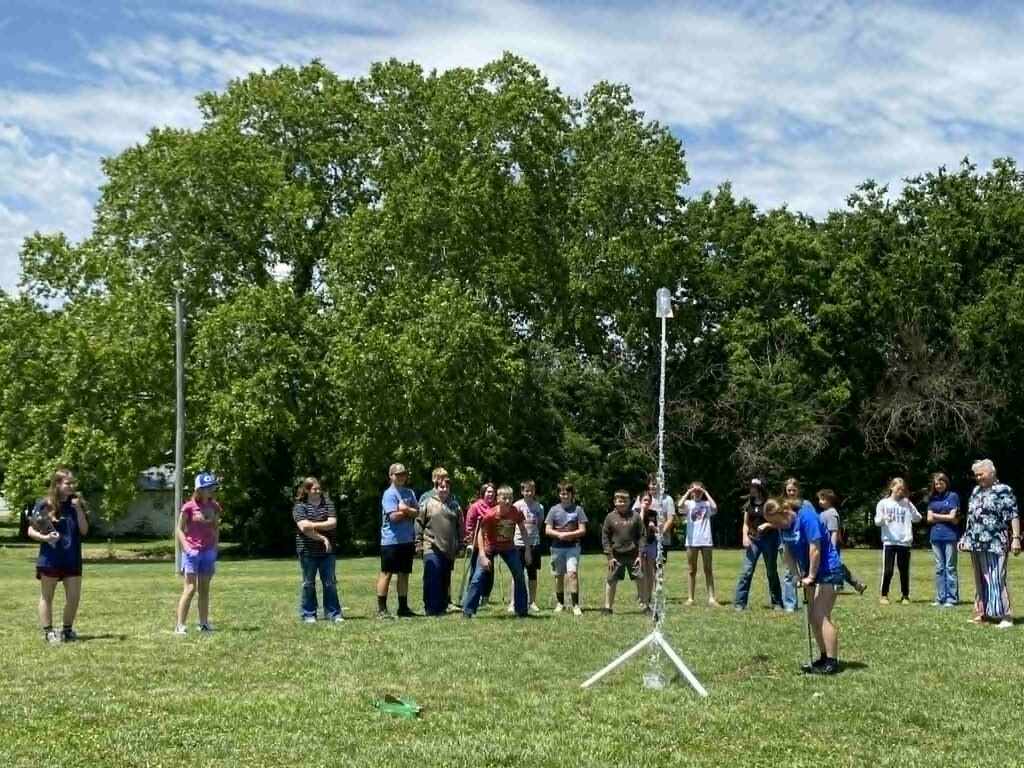 image of students watching a water rocket science demonstration outside