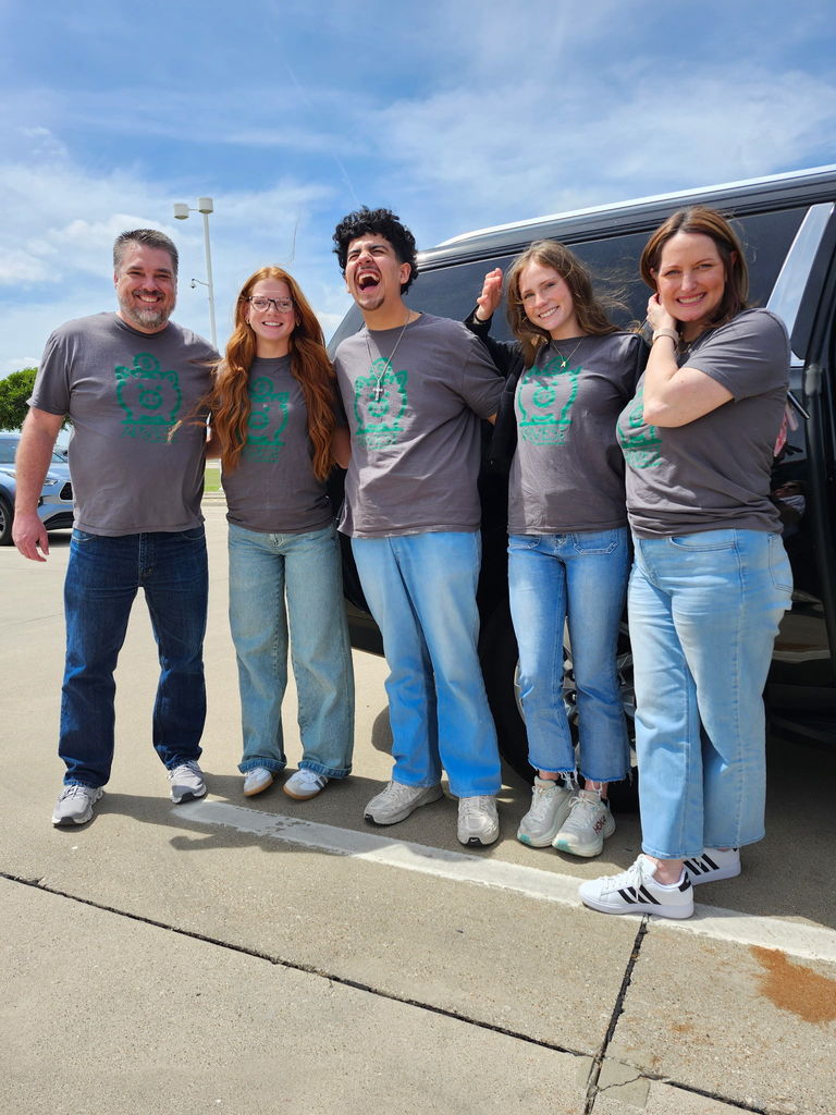 students standing outside in front of a vehicle