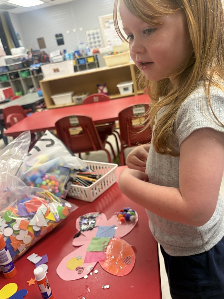 student creating a butterfly with art supplies
