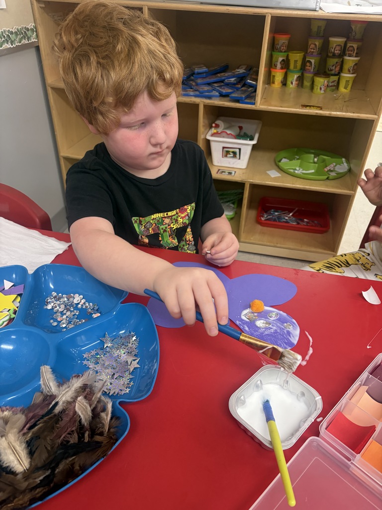 student creating a butterfly with art supplies