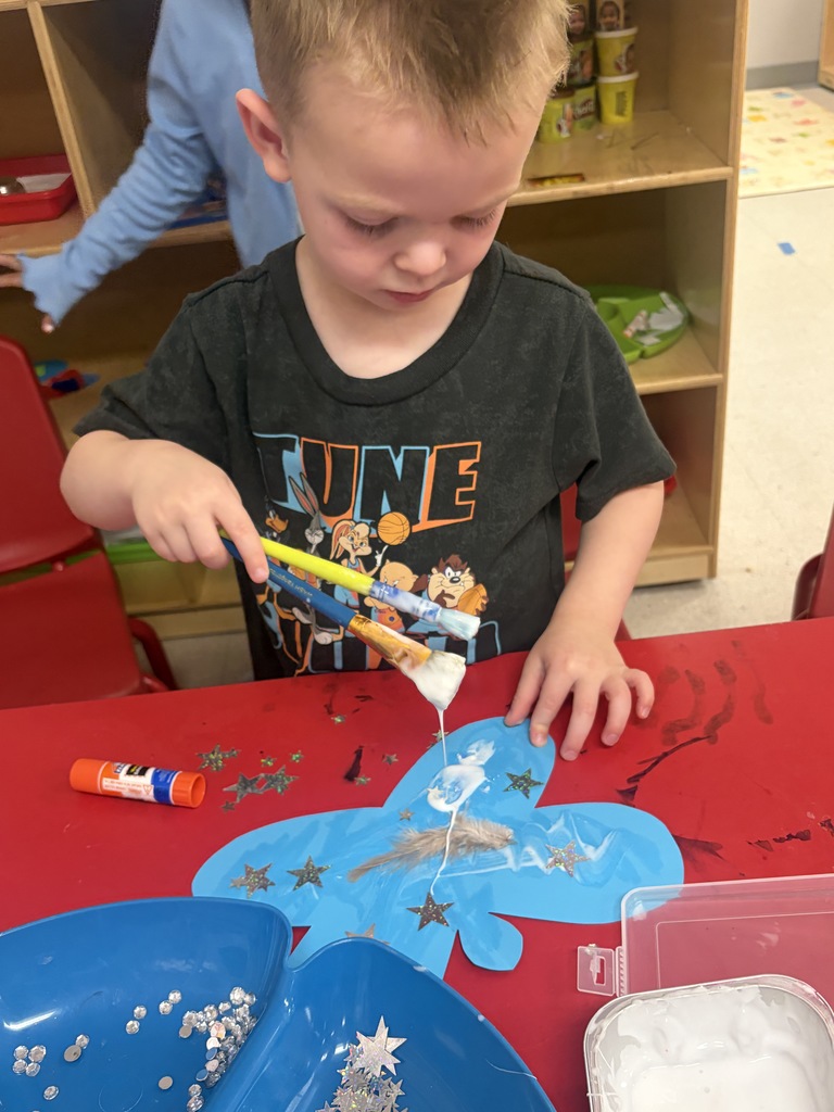 student creating a butterfly with art supplies