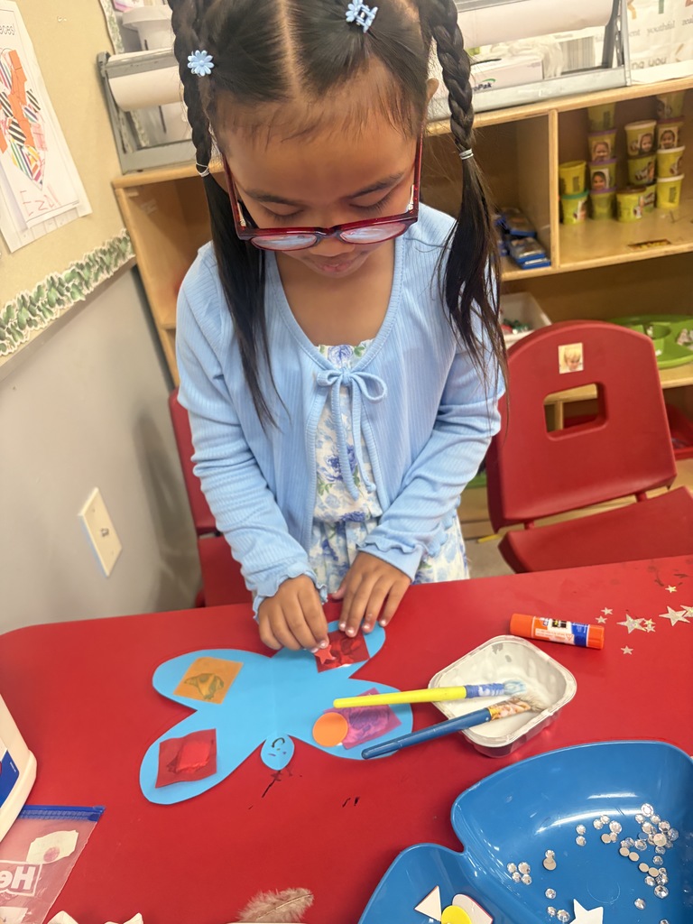 student creating a butterfly with art supplies