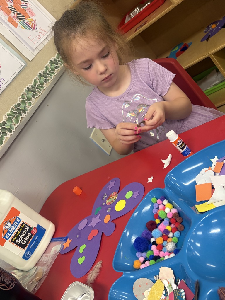 student creating a butterfly with art supplies