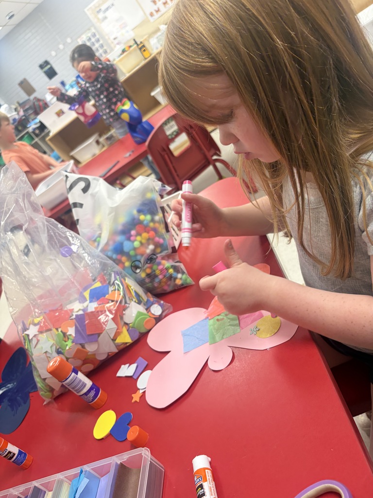 student creating a butterfly with art supplies