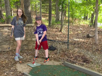 two students playing mini-golf
