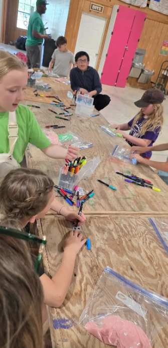 students at a table with markers
