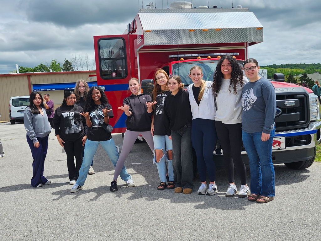 students posing in front of an emergency vehicle
