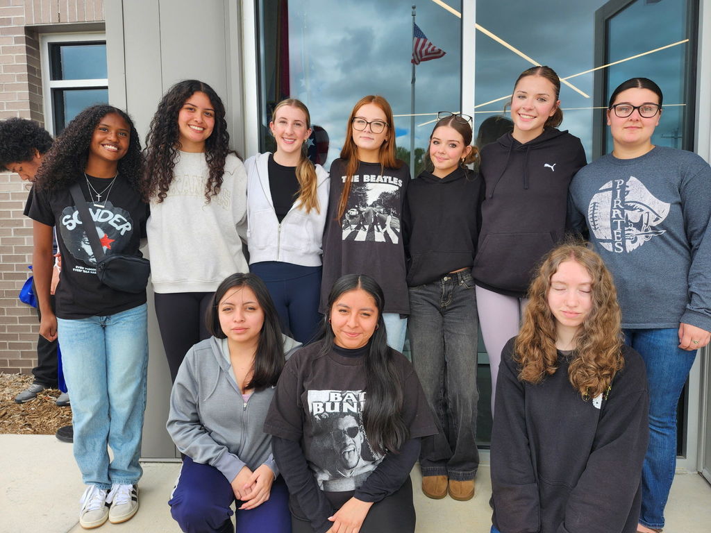 students posing in front of a building