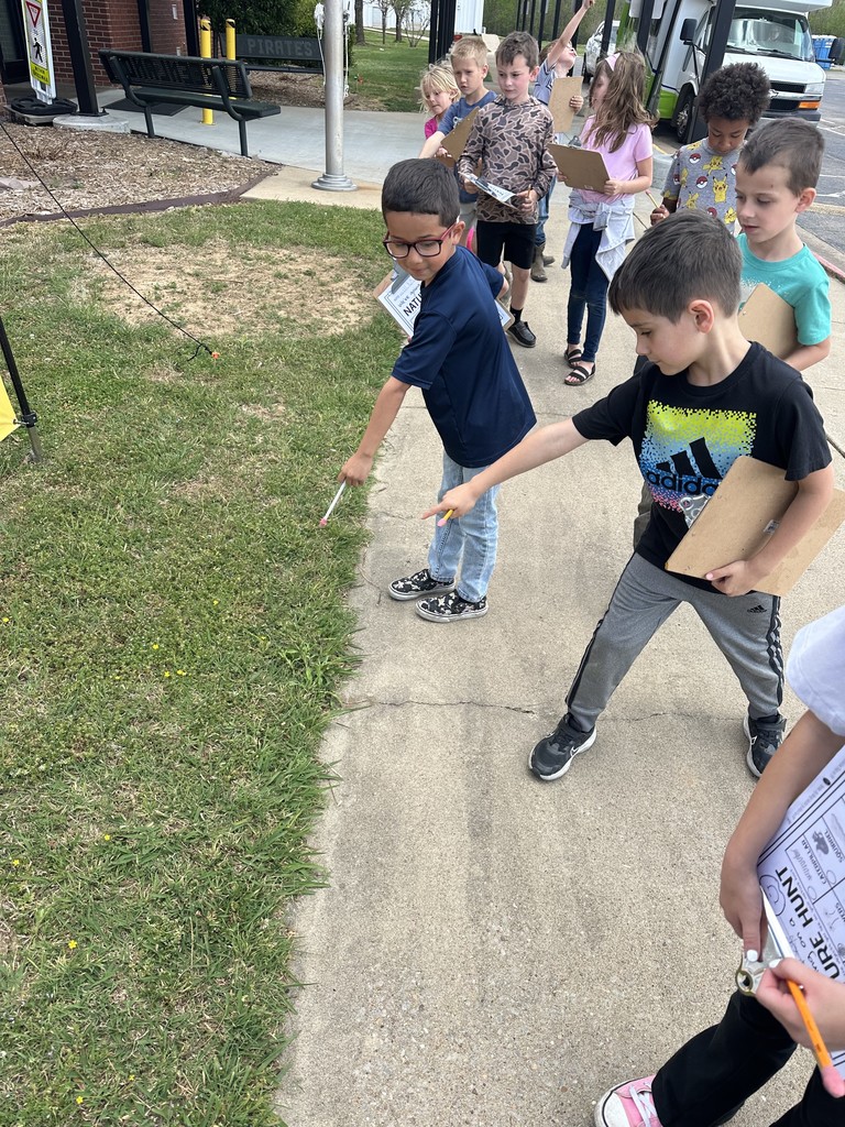 students pointing at a flower