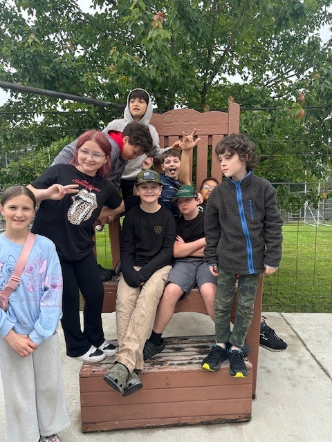 nine students on a giant chair