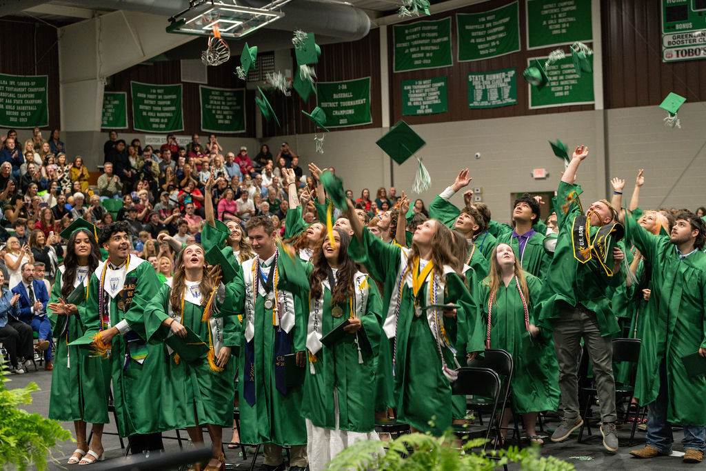 students graduating throwing caps in the air
