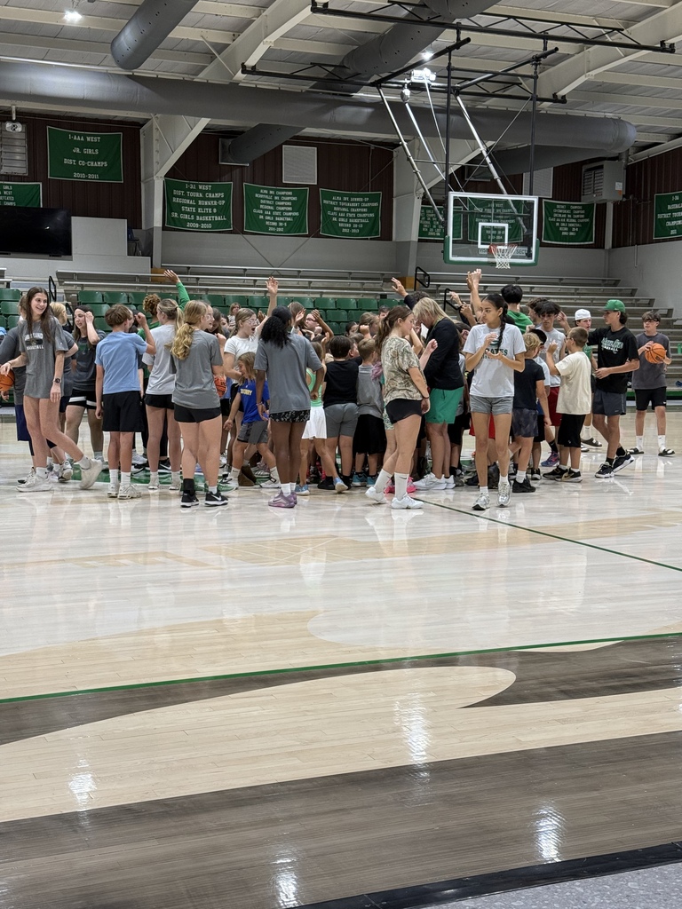 students in a group high fiving on a basketball court
