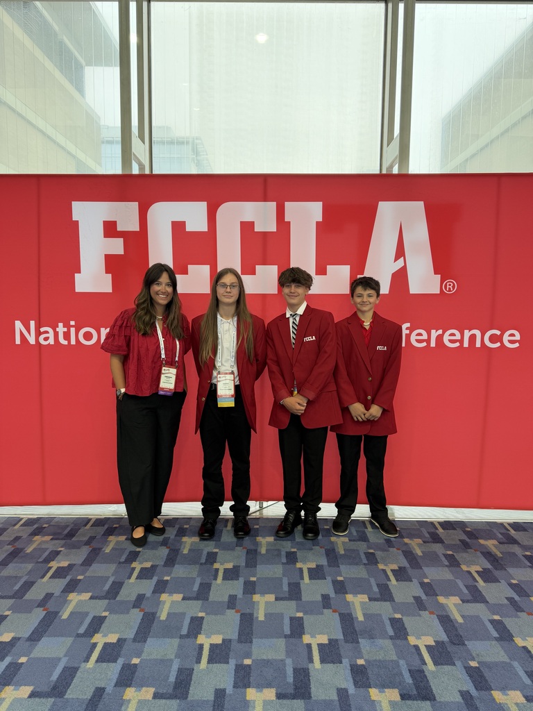 fccla national conference sign in background with four standing in front