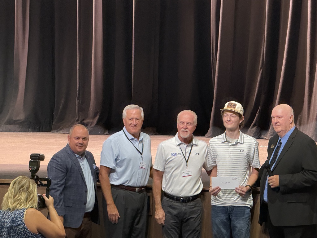 4 people standing together with one holding an envelope