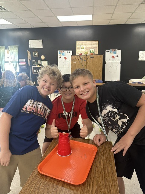 students posing with a tray and cup