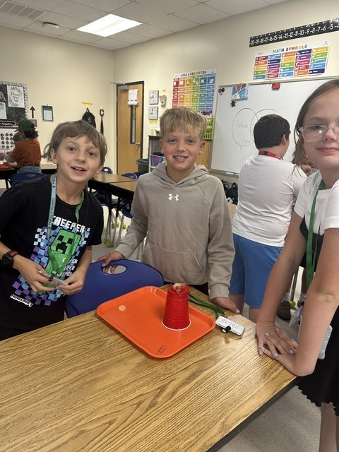 students posing with a tray and cup
