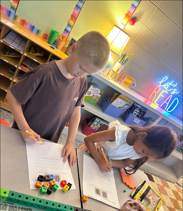 2 kids writing on paper
