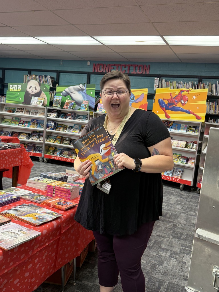 person holding a book with books in the background